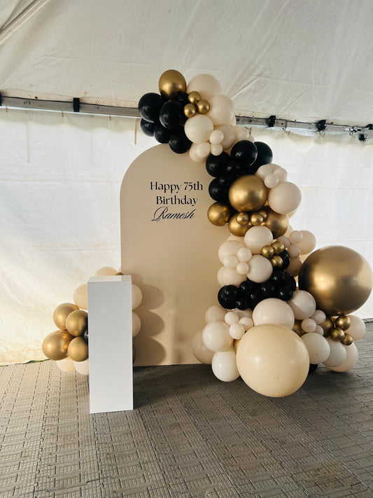 Balloon backdrop with sand black and gold baloons 
